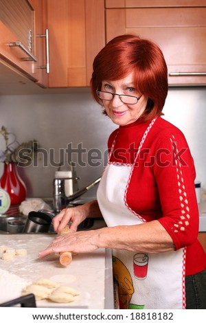 A middle aged smiling woman cooking traditional Russian dish, pelmeni