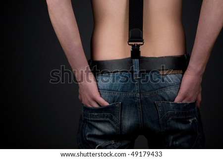 Man in jeans over black background. Back view