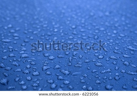 Water drops pattern over a waterproof cloth, blue background
