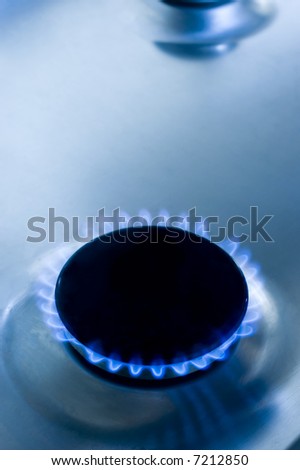 Blue flame of gas stove in a glossy light blue iron plate