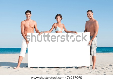 Happy smiling group of friends holding a white board for your text at summer beach
