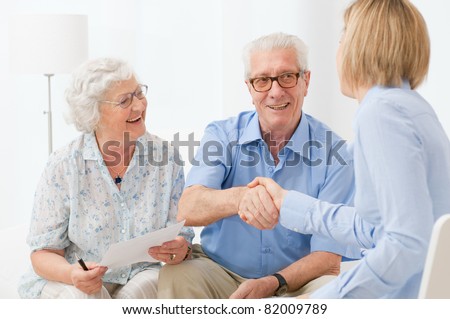 Happy senior couple sealing with an handshake a contract for the retirement