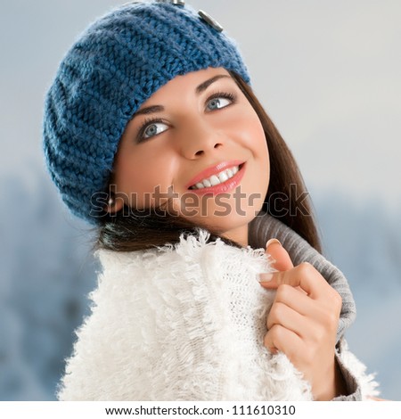 Happy beautiful young woman in warm soft clothes outdoor in a winter day