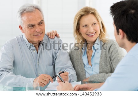 Portrait Of Happy Senior Couple Talking With A Young Man