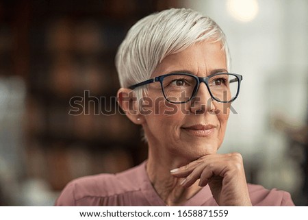 Beautiful senior business woman thinking and wearing spectacles. Thoughtful old woman teacher looking away with eyeglasses. Closeup face of mature pensive lady contemplating the future with copy space