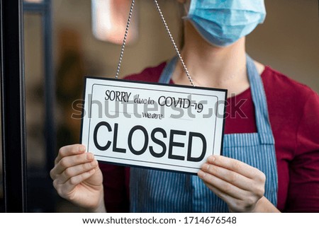 Businesswoman closing her business activity due to covid-19 lockdown. Owner with surgical mask close the doors of her store due to quarantine coronavirus. Close up sign due to the effect of COVID-19. Stock foto © 