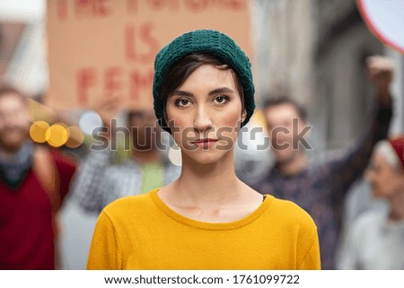 Portrait of confident woman in march fighting for freedom. Young latin woman empowerment strike on street. Casual girl in march to protest on equality rights.