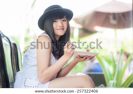 Young asian woman eat bakery in coffee shop, look at camera