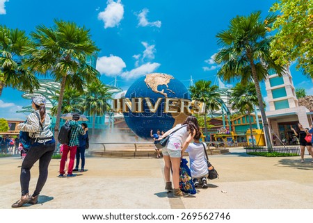 SINGAPORE - MARCH 6: Tourists and theme park visitors taking pictures of the large rotating globe fountain in front of Universal Studios on MARCH 6, 2015 in Sentosa island, Singapore
