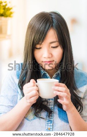 Asian young woman sitting in vintage cafe looking in cup of coffee, Vintage woman coffee