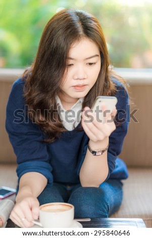 woman with smart phone in coffee shop, Asian woman with phone.