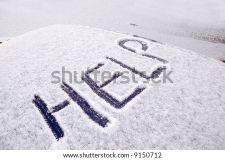Snow covered car with the word help written on the roof
