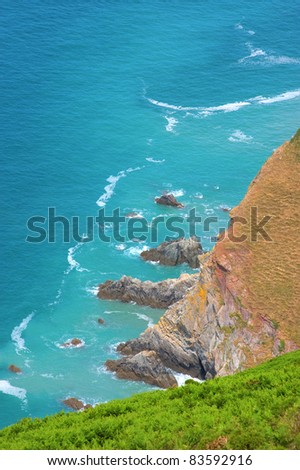 Looking down over cliffs to a rocky foreshore and the deep blue ocean
