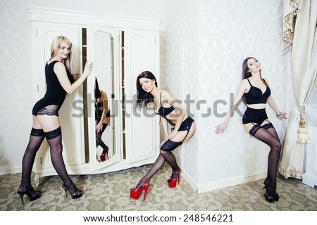 Group of young woman in black lingerie and stockings getting ready for strip-plastic performance.