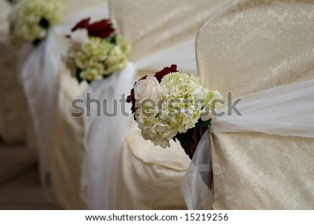 An image of floral arrangements located on seats at a wedding ceremony