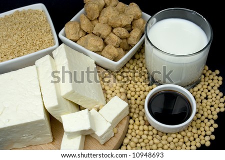Soy sauce, tofu, soy milk and meat alternative on black background