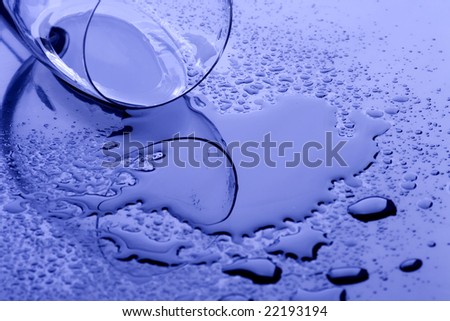 Glass of water spilled on reflective surface