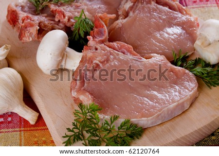 Raw pork loin chops meat with edible mushrooms and herbs