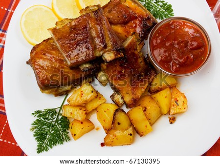 Delicious honey glazed ribs with baked potato on white plate