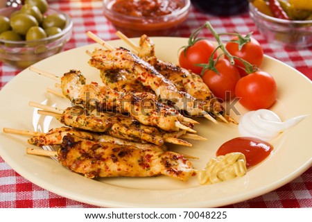 Grilled chicken white meat on skewer with mustard, ketchup an mayonnaise