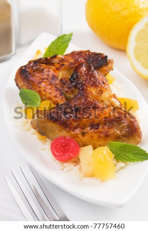 Grilled chicken wings served with rice and tropical fruit