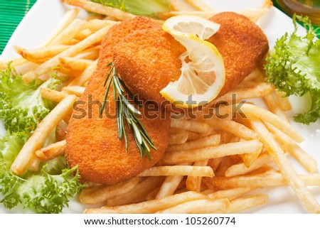 Breaded fish with french fries, lettuce and lemon