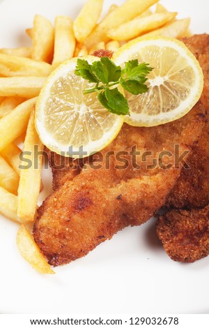Viener schnitzel, breaded steak with french fries and lemon