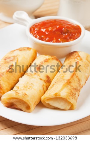 Fried asian egg rolls with hot pepper ant tomato sauce