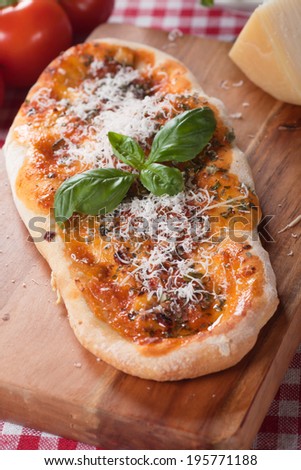 Plain homemade italian pizza with tomato sauce, basil and parmesan cheese