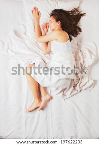 Young girl sleeping in bed, shot from above