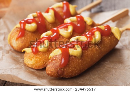 Corn dog, fried sausage in batter with mustard and ketchup