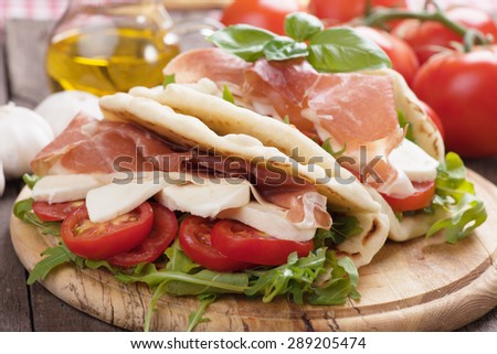 Piadina romagnola, italian flatbread sandwich with rocket salad, ricotta cheese and prosciutto