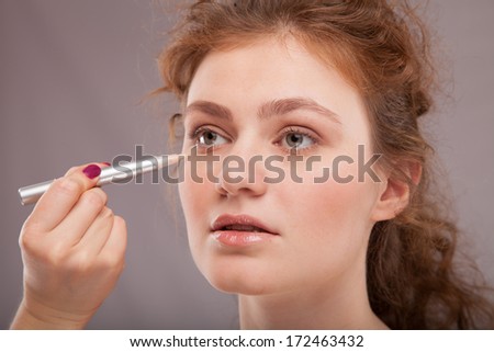 Makeup. Cosmetic. Base for Perfect Make-up.Applying Make-up, red hair girl with perfect skin