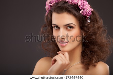 Beautiful Brunette Girl. Healthy Long Hair and Holiday Makeup. Perfect skin. Flowers in hair