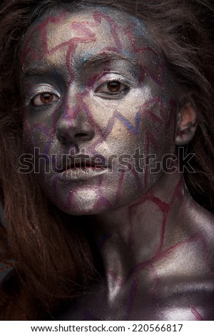 Beautiful face of a woman covered in glitter Close up of a woman\'s face covered in silver glitter