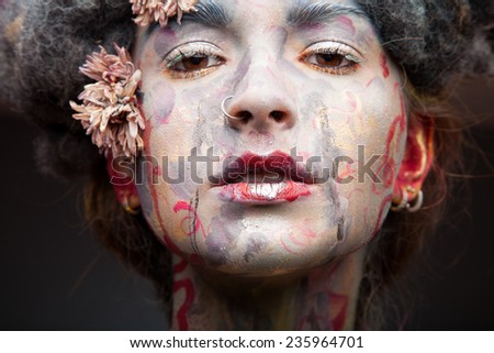 Portrait of young beautiful woman with fancy make-up and vintage flowers. Grey hair and creative face art.