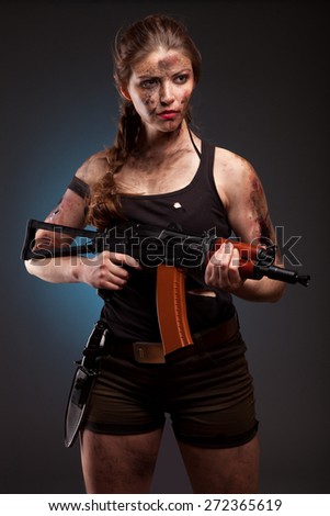 Sexy woman with weapon on dark background. Riot girl.