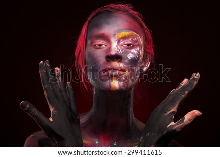 Emotional portrait of a young woman with face paint feeling peace and balance