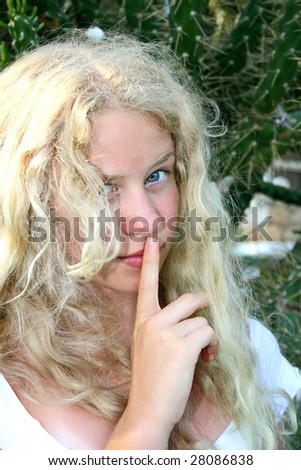 Pretty blond girl finger on her lips.