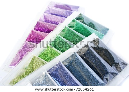 Colorful nail glitters isolated on white background.