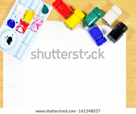 Watercolor brushes, art paper board on wood background