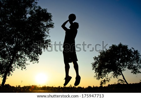 Basketball player with silhouette sunset background as Olympic sport concept