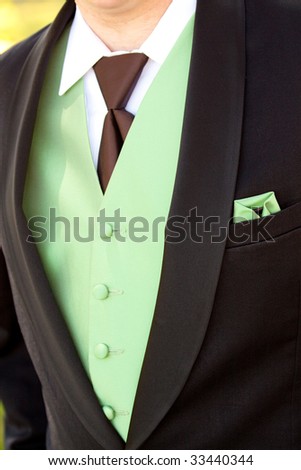A man\'s suit jacket vest and tie in brown and green.