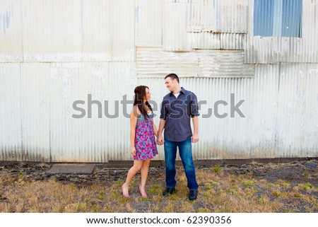 A young couple poses for some engagement photos in urban outdoor settings.