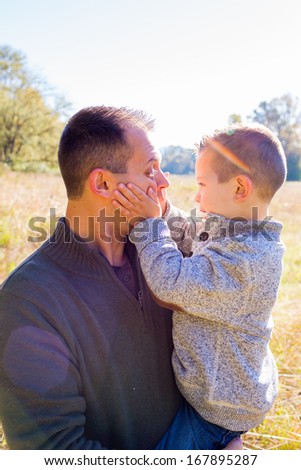 Dad and his son outdoors spending time together with the father and boy both looking happy.