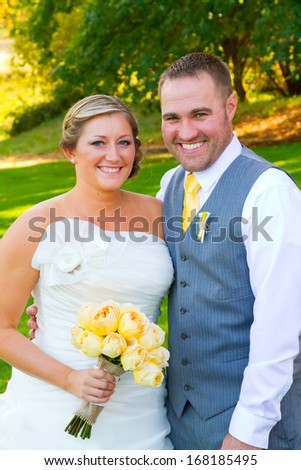 A bride and groom pose for a casual portrait on their wedding day outdoors in the summer in oregon.