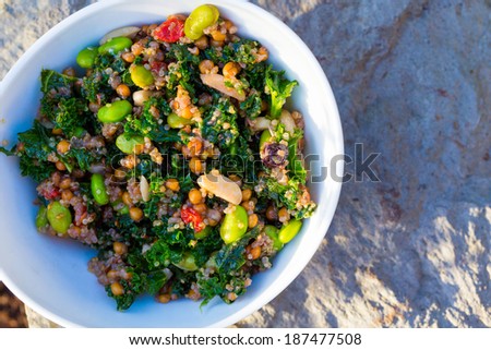 Raw paleo quinoa kale salad in a bowl. Healthy eating diet food.