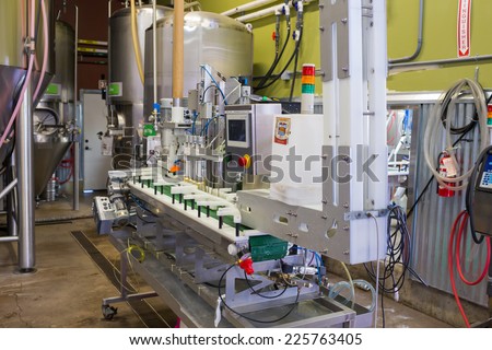 EUGENE, OR - JULY 17, 2014: Can and bottle filling machine on an assembly line at Oakshire Brewing.