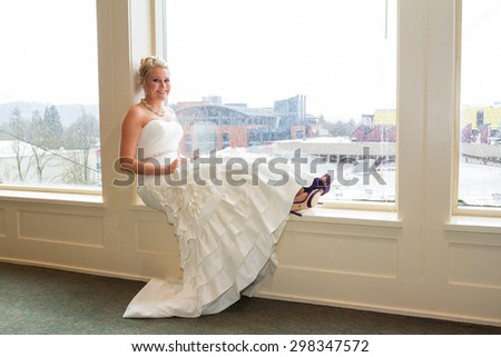 Bride wearing her wedding dress for a portrait indoors since it is rainy outside.