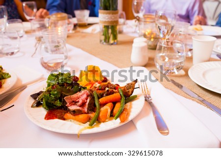 A sit down dinner for a wedding reception meal at a table.